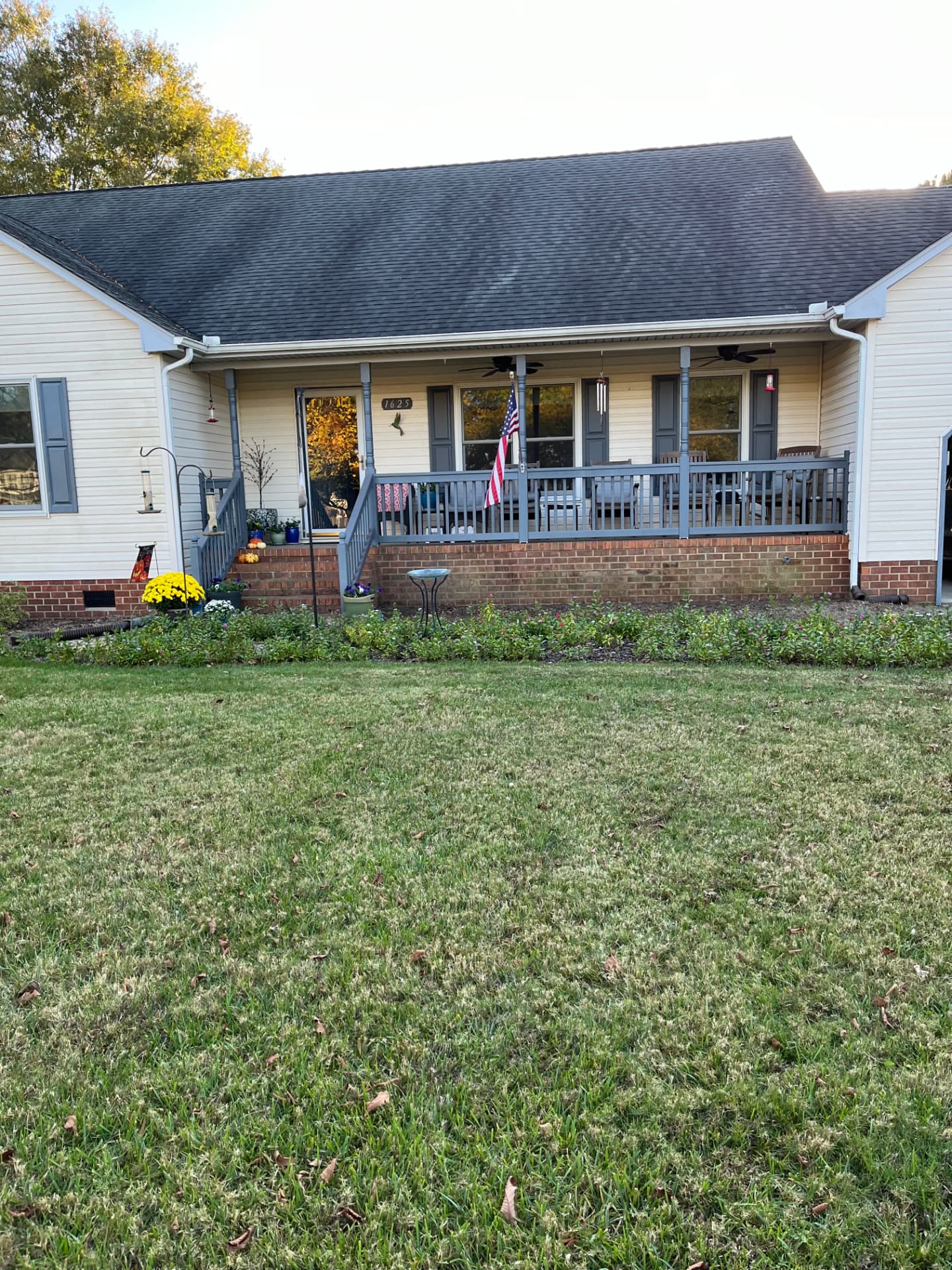 The same Pungo home after both large hedges were removed from the front beds, with the beds opened up and the porch visible again