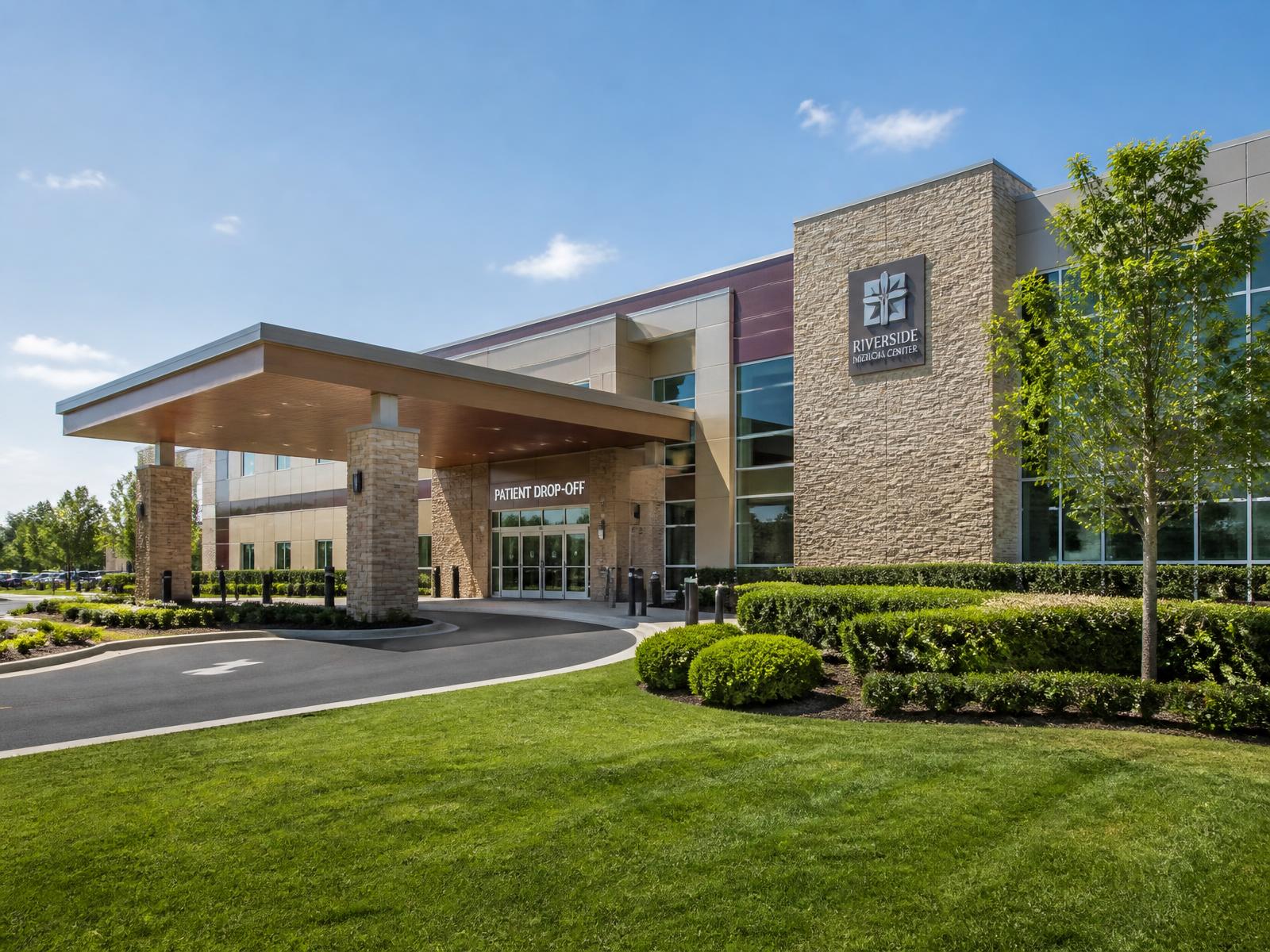 Medical office entrance with trimmed hedges and clean mown grass beside the patient drop-off
