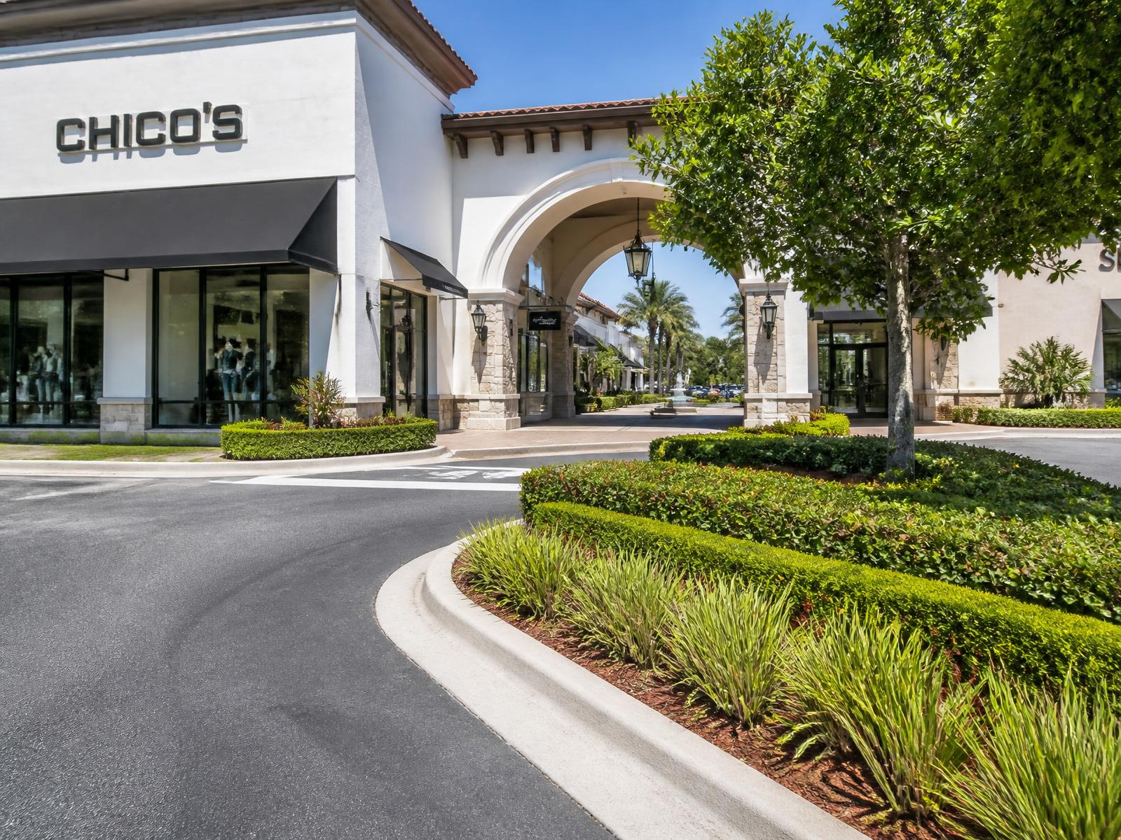 Retail center entrance with edged curbing, clean landscape islands and trimmed hedges